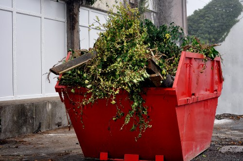 Crew loading green waste onto a covered vehicle following safety procedures